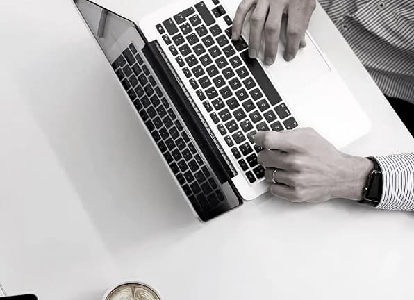 Hands typing on laptop